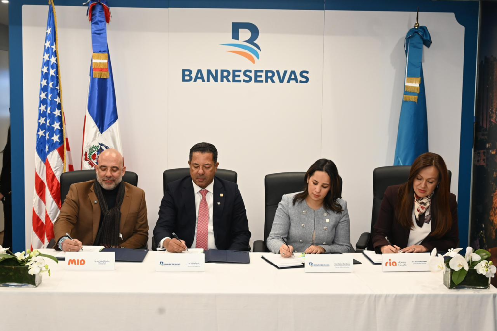 [12:33 p. m., 19/3/2026] Bacilio Valenzuela: Banreservas, MIO y Ria Money Transfer anuncian alianza para fortalecer remesas e inclusión financiera en República Dominicana

La iniciativa impulsa la digitalización de los pagos y amplía el acceso a servicios financieros

Nueva York.- El Banco de Reservas de la República Dominicana, MIO, S.A.S. y Ria Money Transfer anunciaron la firma de una alianza estratégica orientada a fortalecer y modernizar los servicios de envío y recepción de remesas, así como a impulsar la inclusión financiera y la digitalización de los pagos en el país.

El acuerdo fue suscrito en la Oficina de Representación de Banreservas en la ciudad de Nueva York por la vicepresidenta ejecutiva senior administrativa de Banreservas, Alieska Díaz; el vicepresidente ejecutivo senior de Negocios,…
[12:33 p. m., 19/3/2026] Bacilio Valenzuela: José Yude Michelén, presidente de MIO; Ysidro García, vicepresidente ejecutivo senior de Negocios; Alieska Díaz, vicepresidenta ejecutiva senior administrativa; y Rosario Escarpita, SVP & Managing Director para las Américas de Ría Money Transfer
[12:33 p. m., 19/3/2026] Bacilio Valenzuela: José Yude Michelén, presidente de MIO; Ysidro García, vicepresidente ejecutivo senior de Negocios; Alieska Díaz, vicepresidenta ejecutiva senior administrativa; y Rosario Escarpita, SVP & Managing Director para las Américas de Ría Money Transfer, durante firma de acuerdo